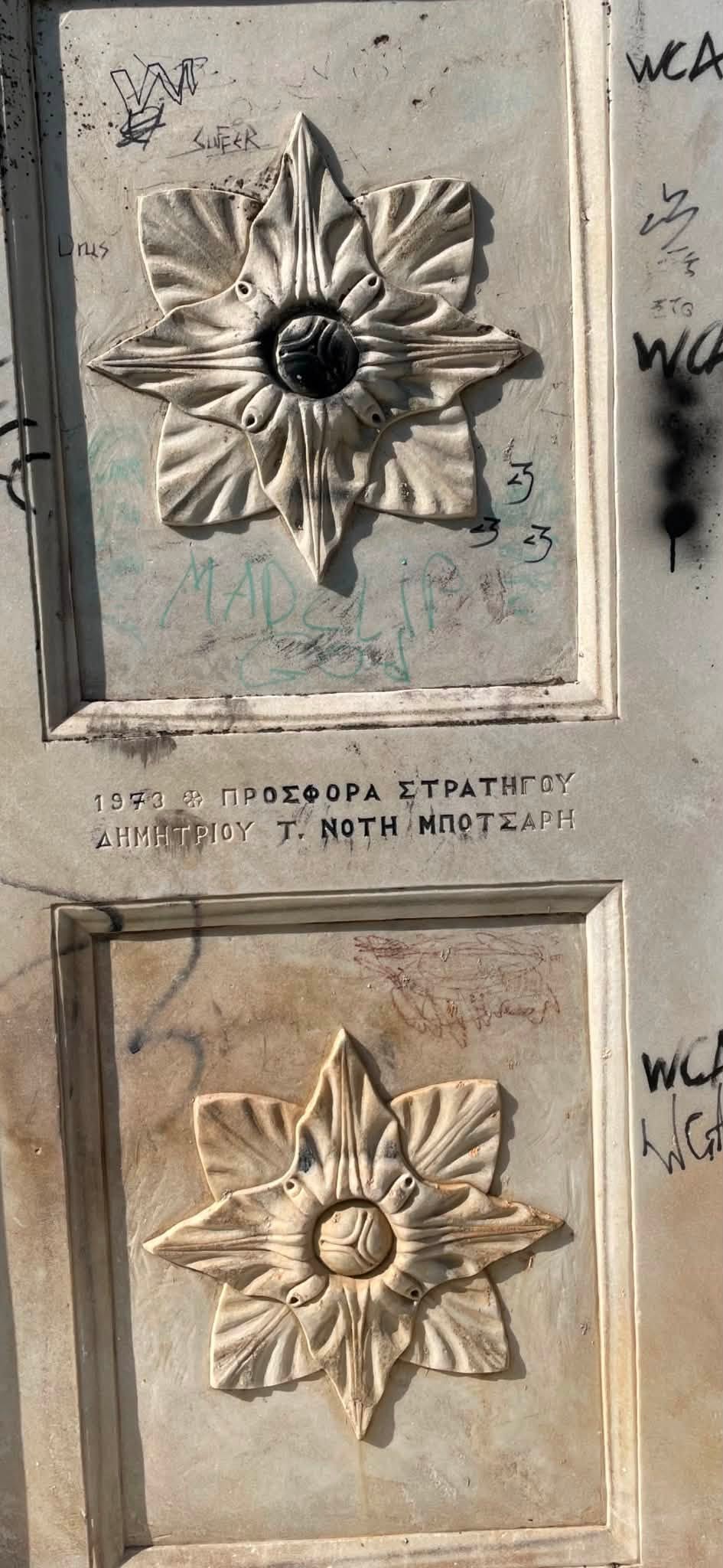 Λεπτομέρεια του μνημείου στη Ζάκυνθο με την επιγραφή «1973 Προσφορά Στρατηγού Δημητρίου Τ. Νότη Μπότσαρη», καλυμμένη με γκράφιτι